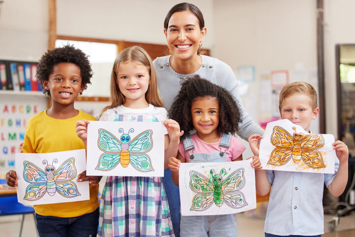 early childcare assistant displaying artwork with students