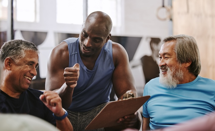 Certified personal trainer in Canada working with two older men on fitness goals